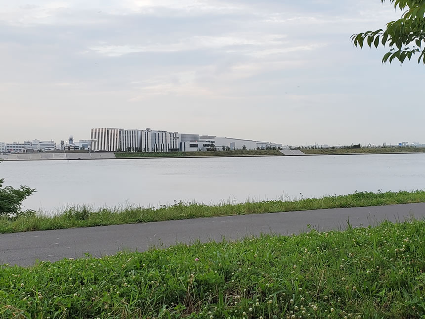 多摩川河川敷のサイクリングロードと遊歩道から見た羽田イノベーションシティ。